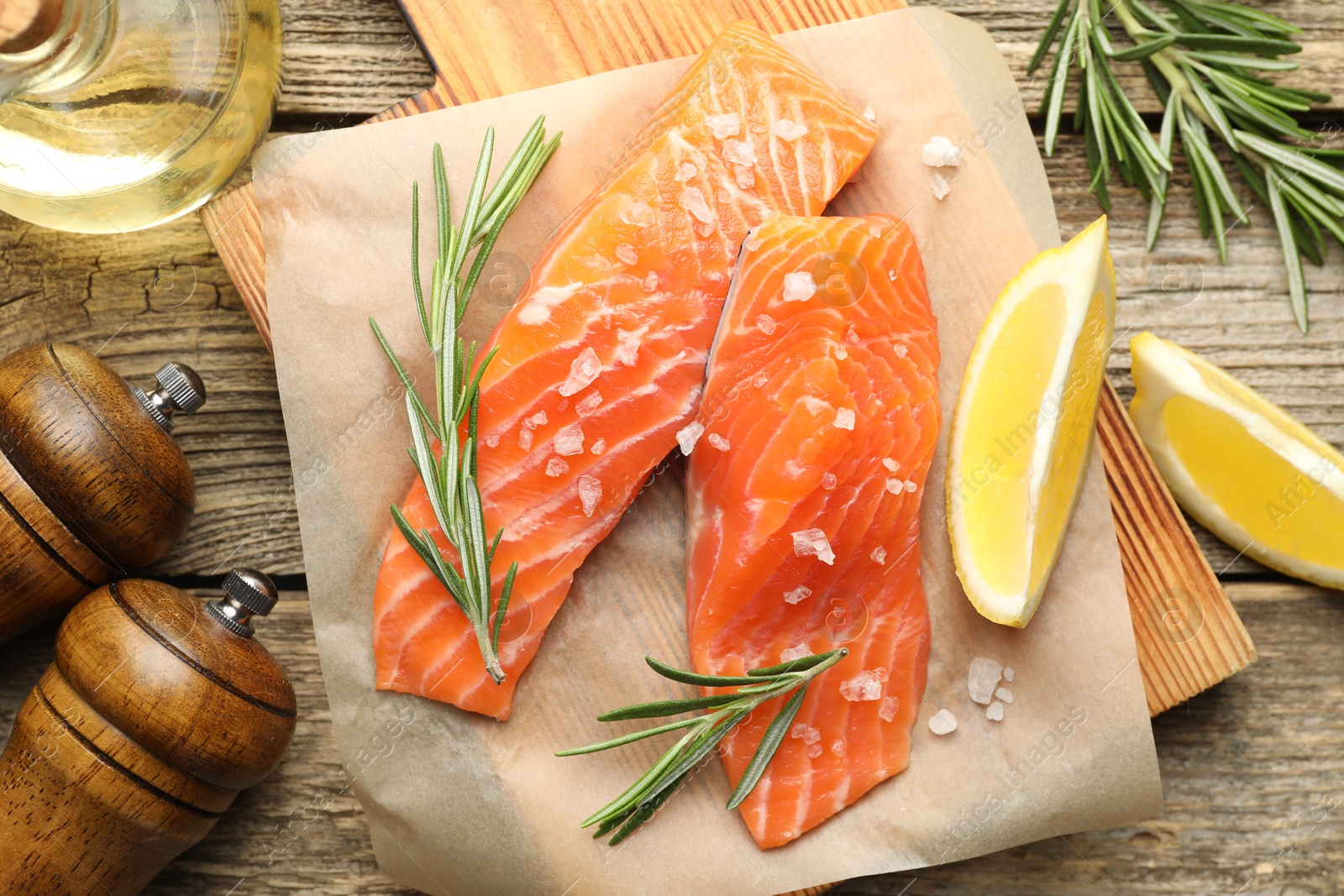 Seafood. Pieces of salmon fillet, spices, oil and lemon wedges on wooden table, flat lay Photo of Seafood. Pieces of salmon fillet, spices, oil and lemon wedges on wooden table, flat lay