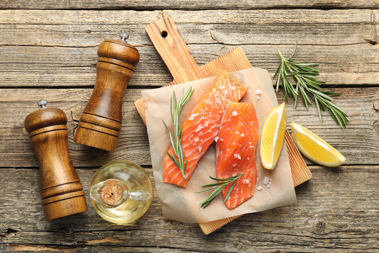 Seafood. Pieces of salmon fillet, spices, oil and lemon wedges on wooden table, flat lay Photo of Seafood. Pieces of salmon fillet, spices, oil and lemon wedges on wooden table, flat lay