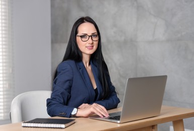 Photo of Professional psychologist working with laptop at table in office