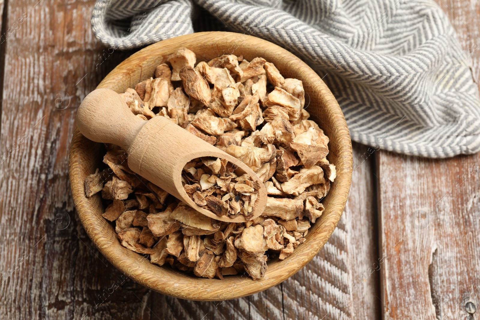 Pieces of dry chicory roots in bowl and scoop on wooden table, top view Photo of Pieces of dry chicory roots in bowl and scoop on wooden table, top view