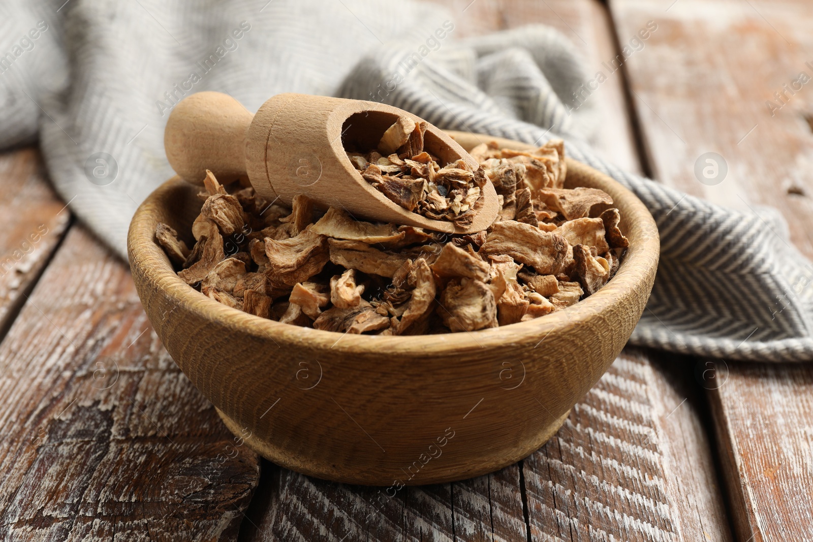 Pieces of dry chicory roots in bowl and scoop on wooden table, closeup Photo of Pieces of dry chicory roots in bowl and scoop on wooden table, closeup