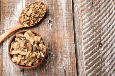 Photo of Pieces of dry chicory roots in bowl and spoon on wooden table, top view. Space for text