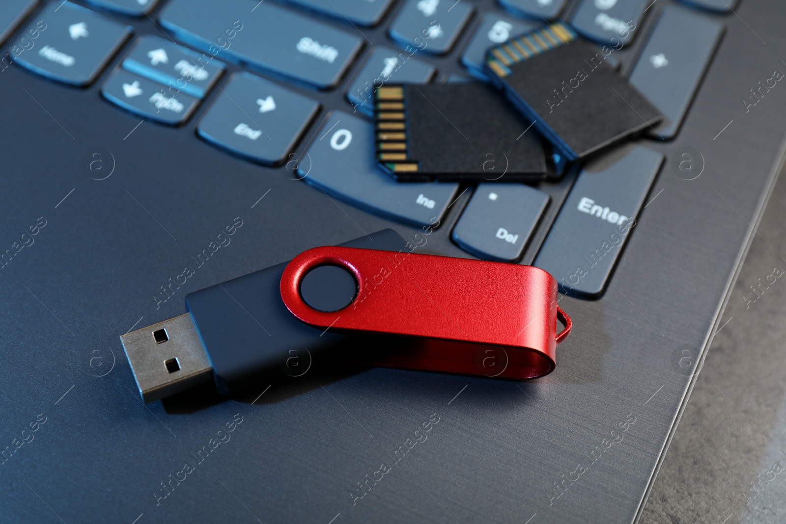 SD memory cards, USB flash drive and laptop on dark grey table, closeup Photo of SD memory cards, USB flash drive and laptop on dark grey table, closeup