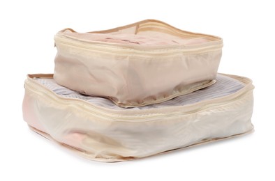 Photo of Beige packing cubes with folded clothes isolated on white