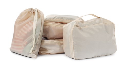 Photo of Beige packing cubes with clothes isolated on white