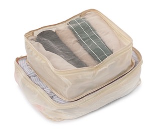 Photo of Beige packing cubes with folded clothes isolated on white