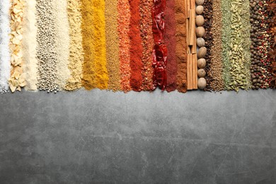 Photo of Many different spices on grey table, flat lay. Space for text