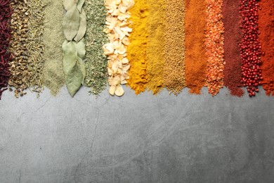 Photo of Many different spices on grey table, flat lay. Space for text
