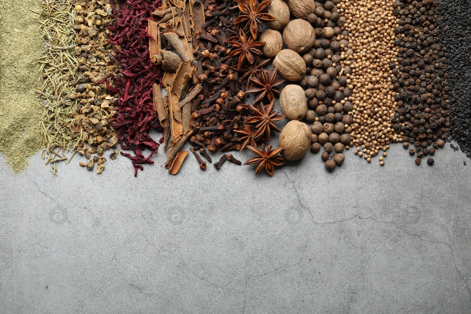 Many different spices on grey table, flat lay. Space for text Photo of Many different spices on grey table, flat lay. Space for text