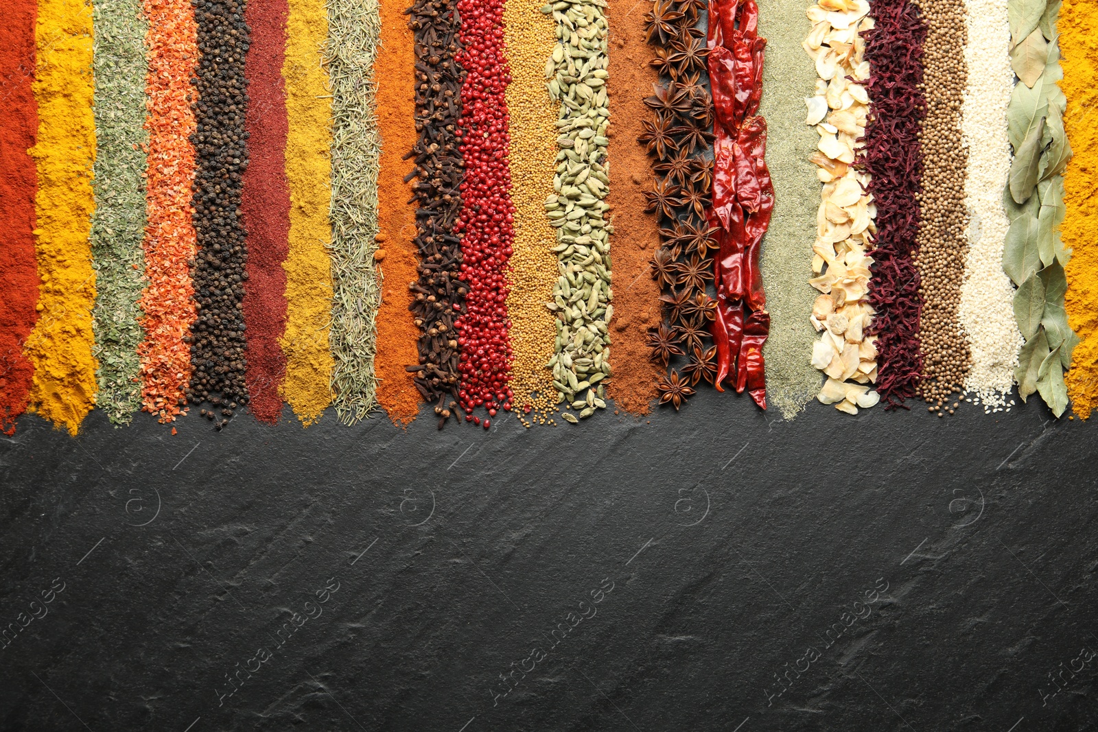 Many different spices on black table, flat lay. Space for text Photo of Many different spices on black table, flat lay. Space for text