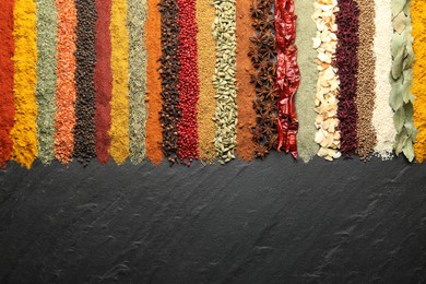 Photo of Many different spices on black table, flat lay. Space for text
