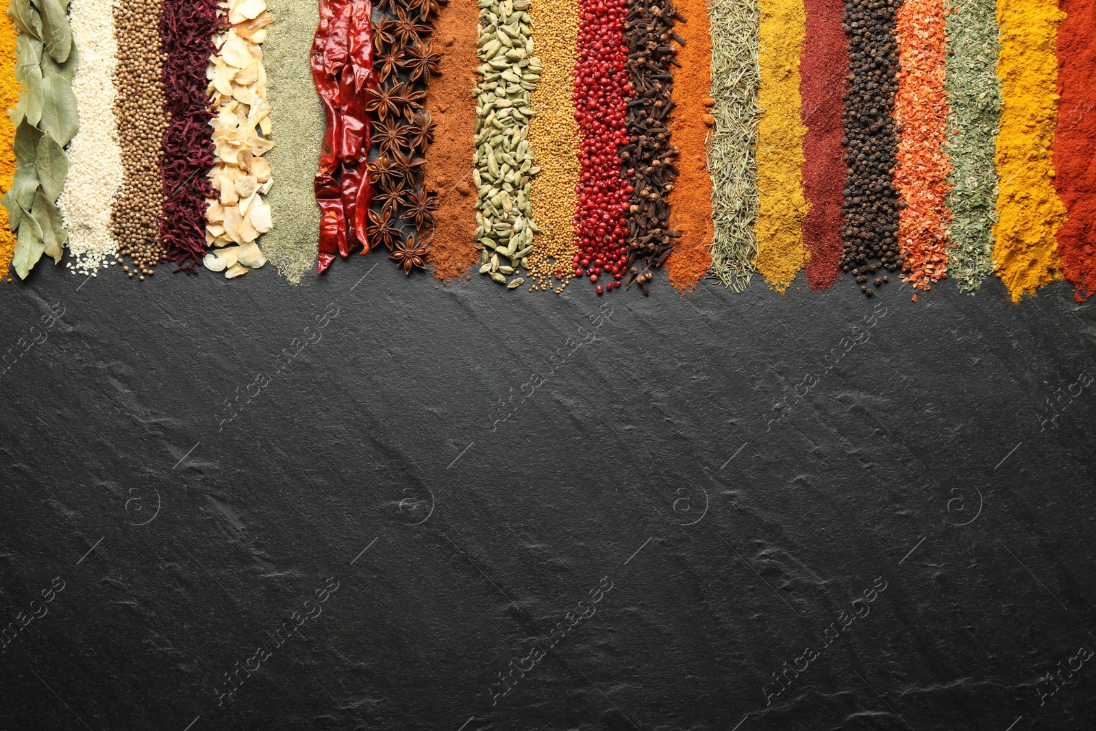 Many different spices on black table, flat lay. Space for text Photo of Many different spices on black table, flat lay. Space for text