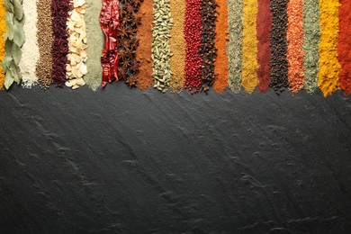 Photo of Many different spices on black table, flat lay. Space for text
