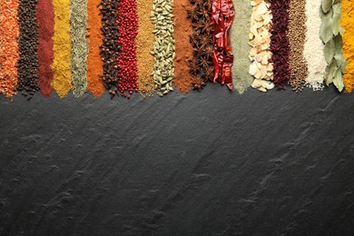 Photo of Many different spices on black table, flat lay. Space for text