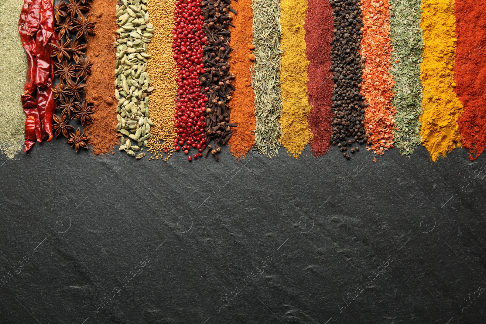 Photo of Many different spices on black table, flat lay. Space for text
