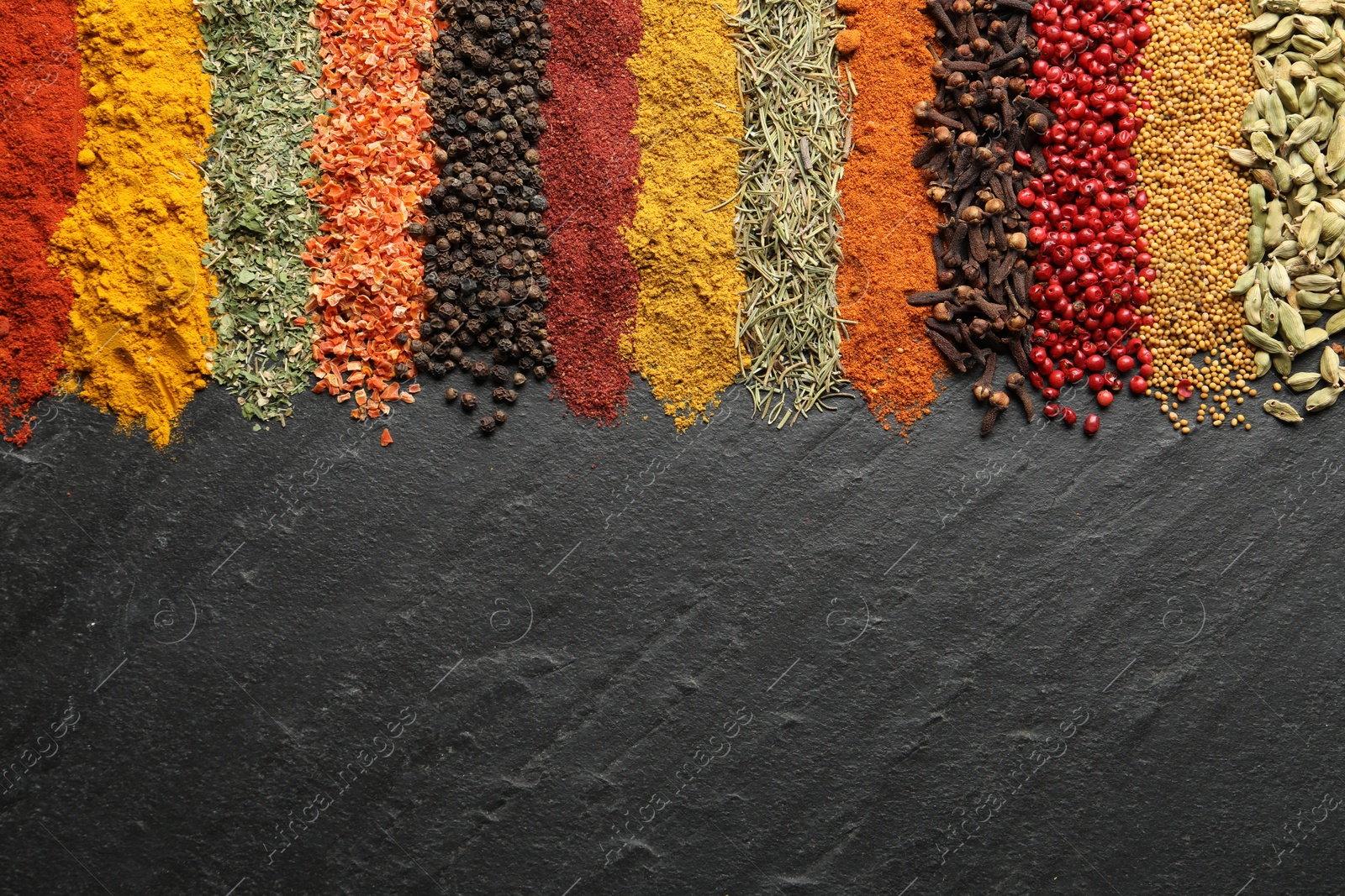 Many different spices on black table, flat lay. Space for text Photo of Many different spices on black table, flat lay. Space for text