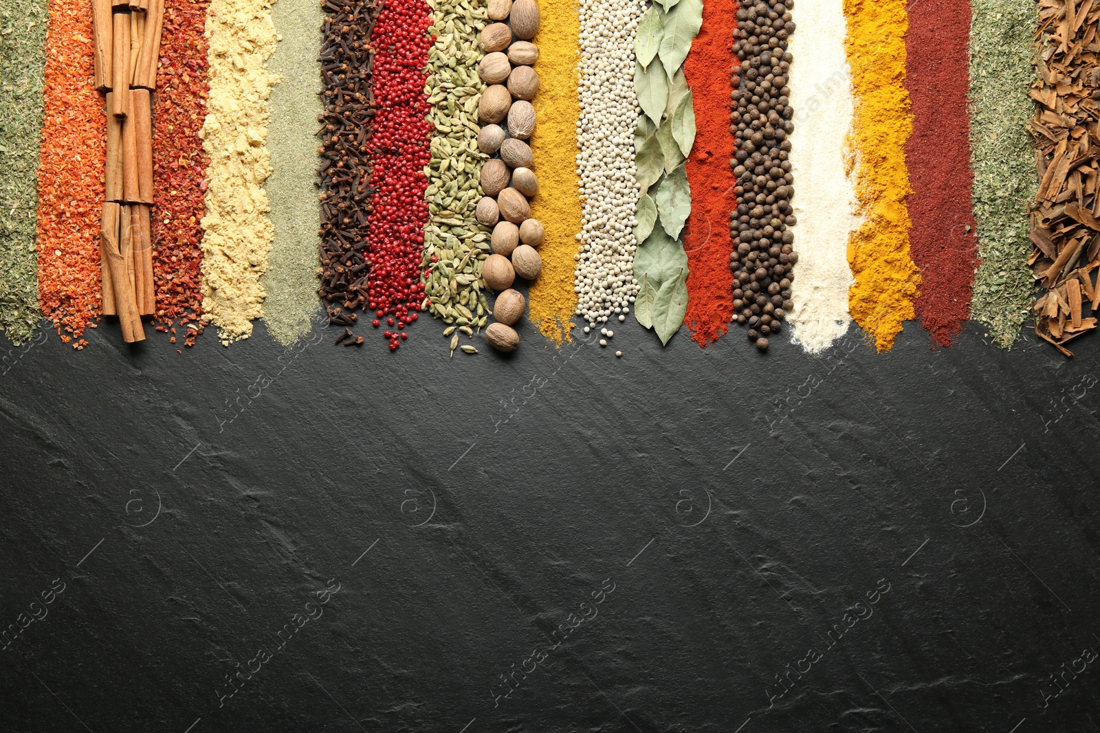 Many different spices on black table, flat lay. Space for text Photo of Many different spices on black table, flat lay. Space for text