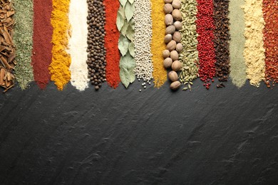 Photo of Many different spices on black table, flat lay. Space for text