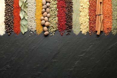 Photo of Many different spices on black table, flat lay. Space for text