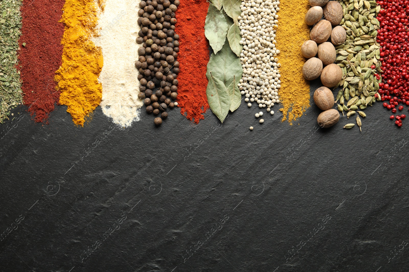 Many different spices on black table, flat lay. Space for text Photo of Many different spices on black table, flat lay. Space for text