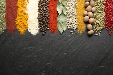 Photo of Many different spices on black table, flat lay. Space for text