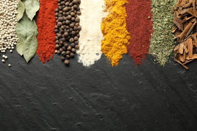 Photo of Many different spices on black table, flat lay. Space for text