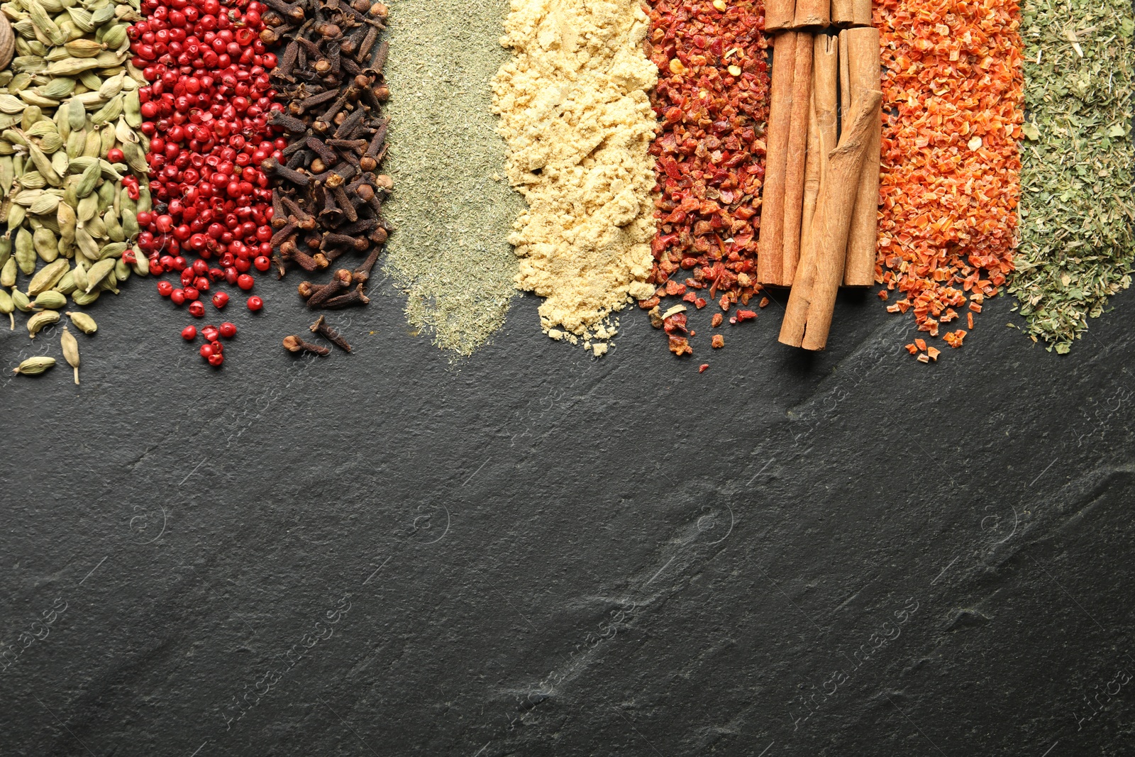 Many different spices on black table, flat lay. Space for text Photo of Many different spices on black table, flat lay. Space for text