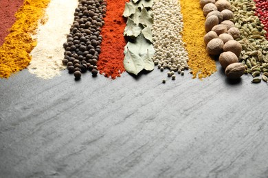 Photo of Many different spices on dark table, closeup. Space for text