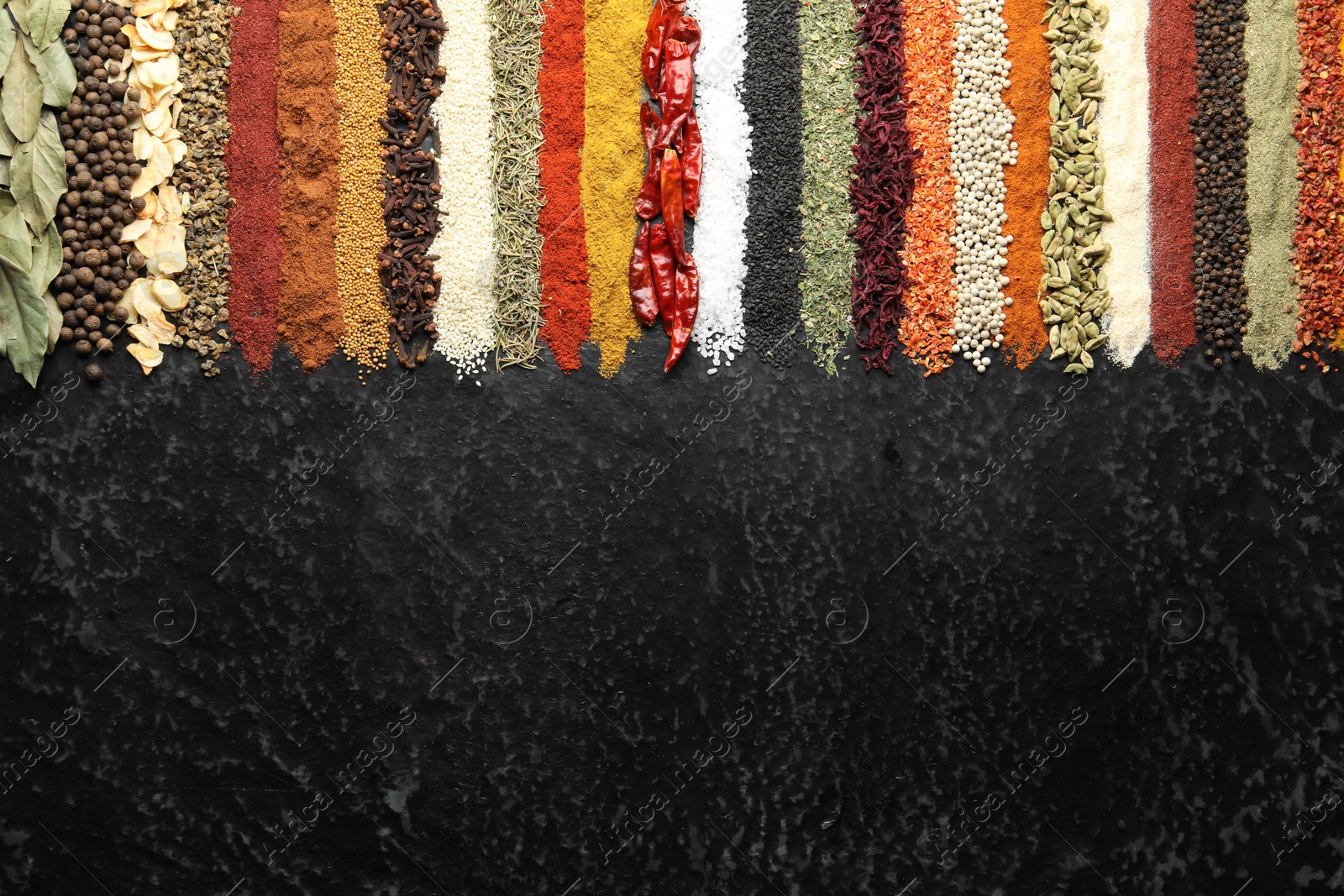 Many different spices on black table, flat lay. Space for text Photo of Many different spices on black table, flat lay. Space for text