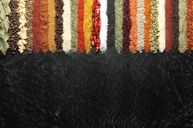 Photo of Many different spices on black table, flat lay. Space for text