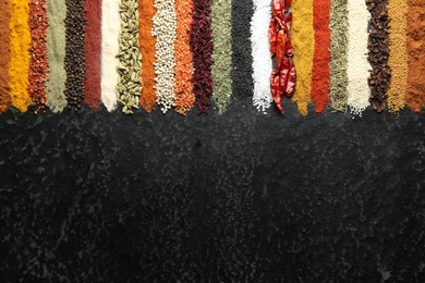 Photo of Many different spices on black table, flat lay. Space for text