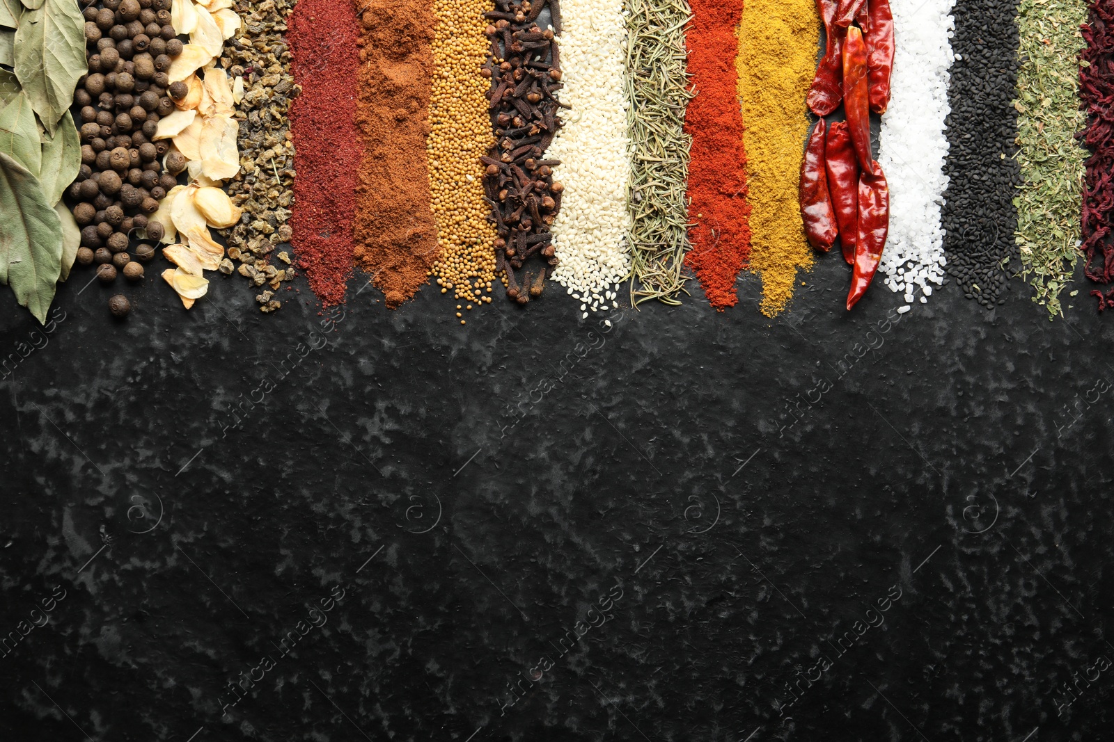 Many different spices on black table, flat lay. Space for text Photo of Many different spices on black table, flat lay. Space for text