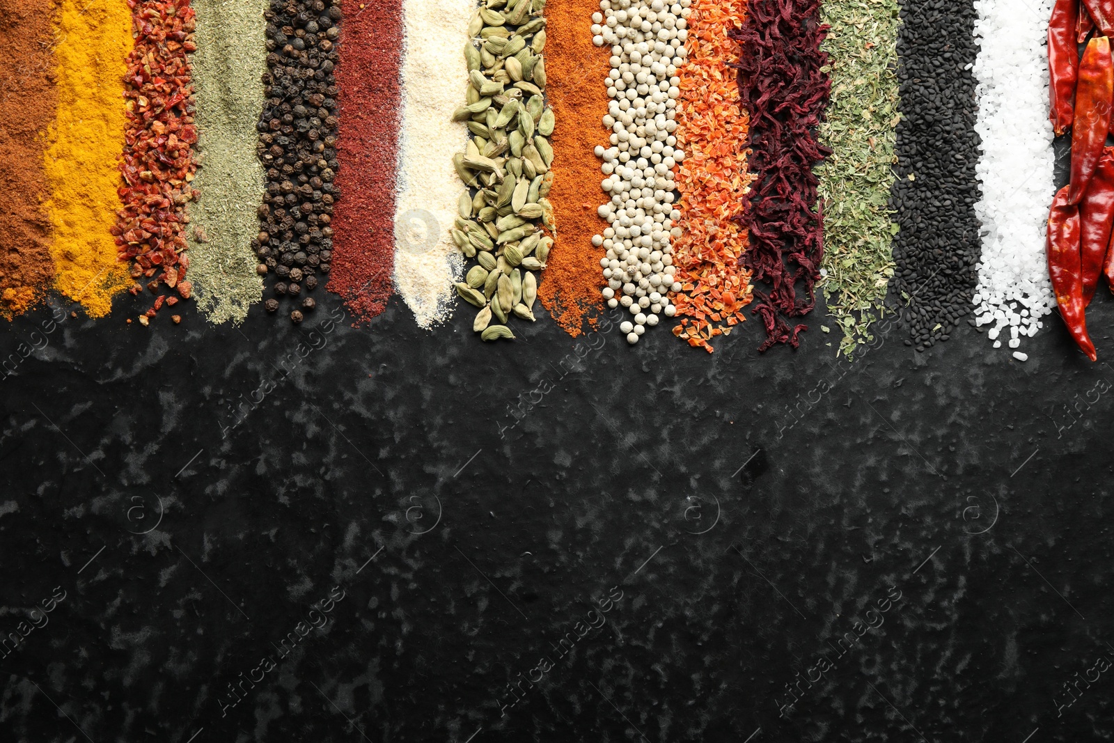 Many different spices on black table, flat lay. Space for text Photo of Many different spices on black table, flat lay. Space for text