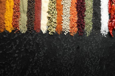 Photo of Many different spices on black table, flat lay. Space for text