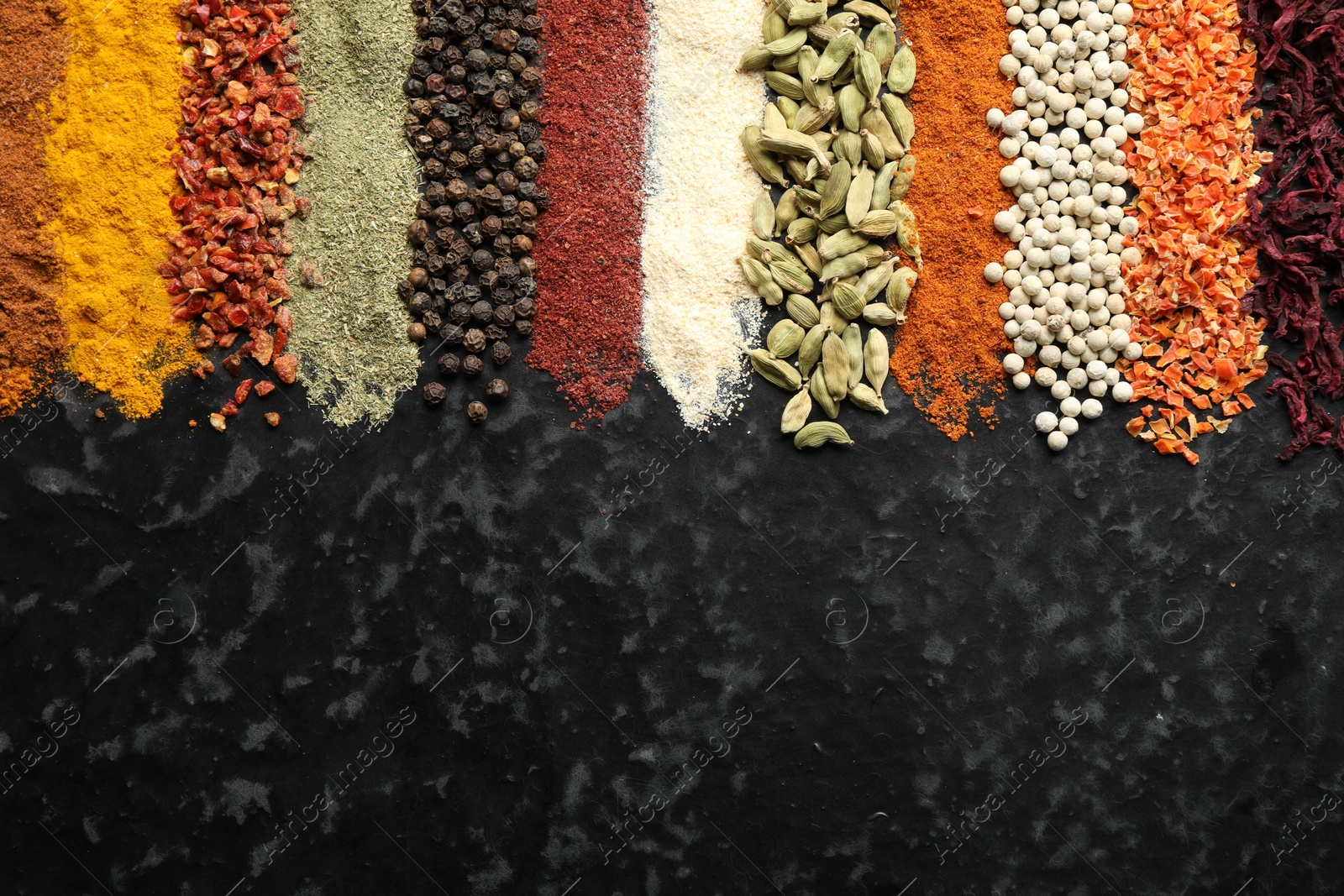Many different spices on black table, flat lay. Space for text Photo of Many different spices on black table, flat lay. Space for text