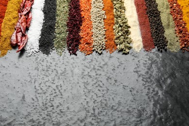 Photo of Many different spices on dark table, closeup. Space for text