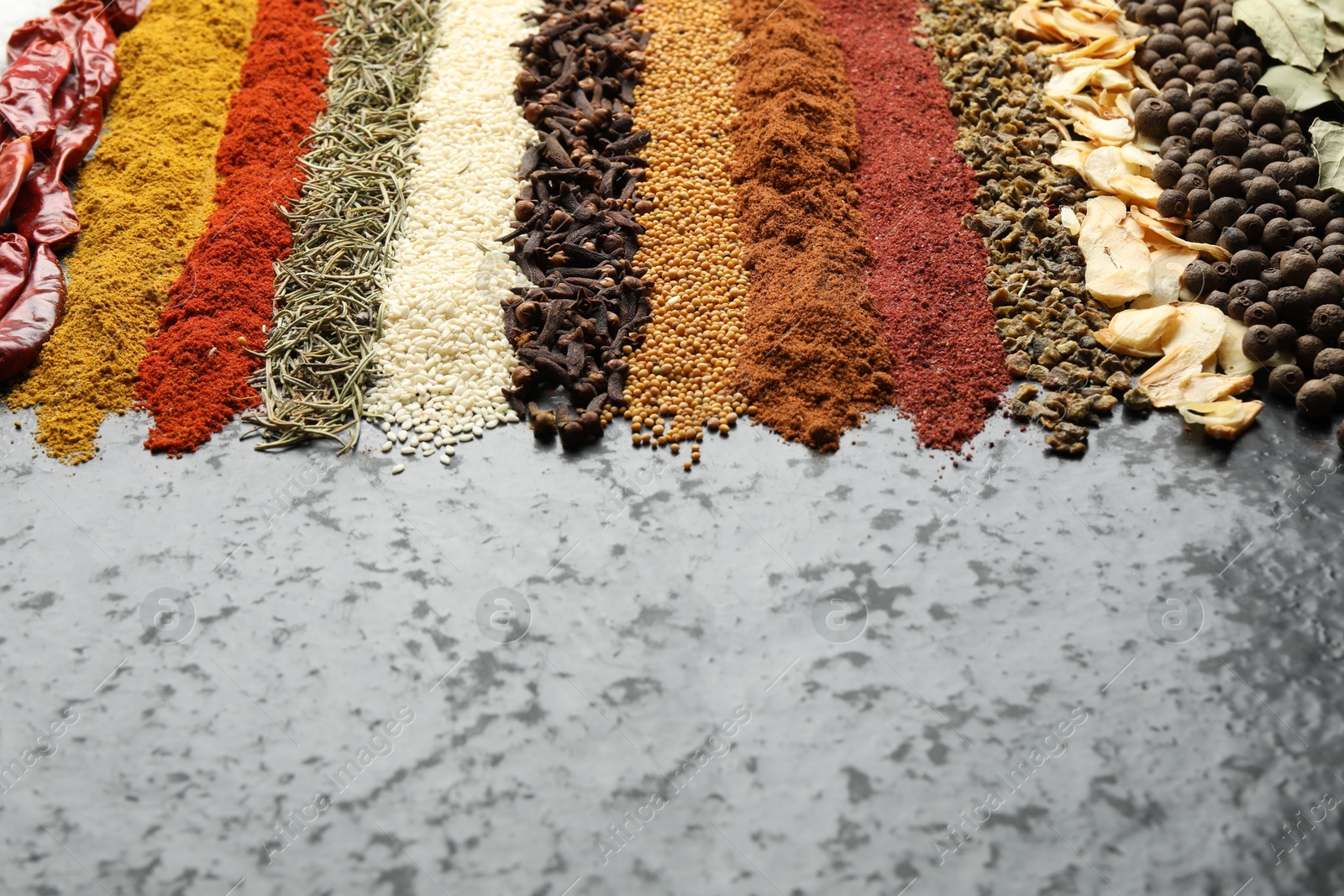 Many different spices on dark table, closeup. Space for text Photo of Many different spices on dark table, closeup. Space for text