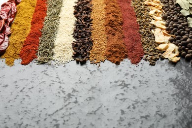 Photo of Many different spices on dark table, closeup. Space for text