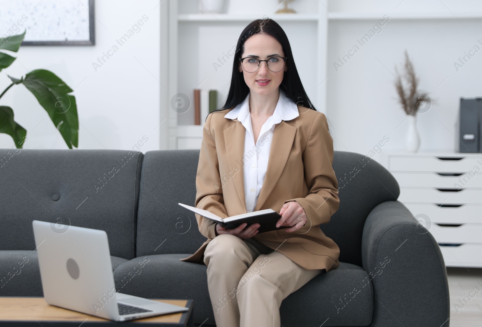 Professional psychologist with notebook and laptop in office Photo of Professional psychologist with notebook and laptop in office