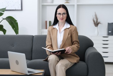Photo of Professional psychologist with notebook and laptop in office