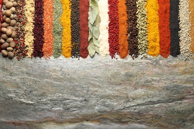 Photo of Many different spices on textured table, flat lay. Space for text
