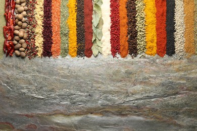 Photo of Many different spices on textured table, flat lay. Space for text