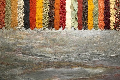 Photo of Many different spices on textured table, flat lay. Space for text