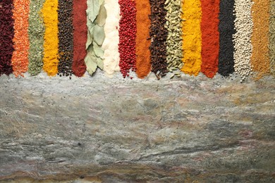 Photo of Many different spices on textured table, flat lay. Space for text