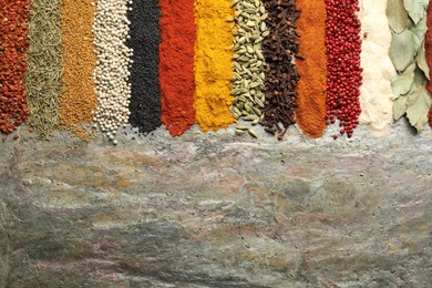 Photo of Many different spices on textured table, flat lay. Space for text
