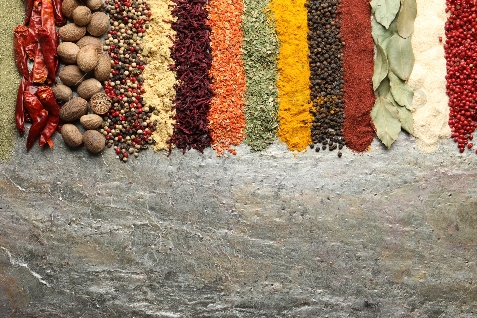 Photo of Many different spices on textured table, flat lay. Space for text