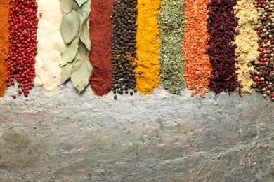 Photo of Many different spices on textured table, flat lay. Space for text