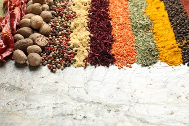Photo of Many different spices on textured table, closeup. Space for text