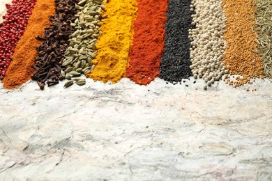 Photo of Many different spices on textured table, closeup. Space for text