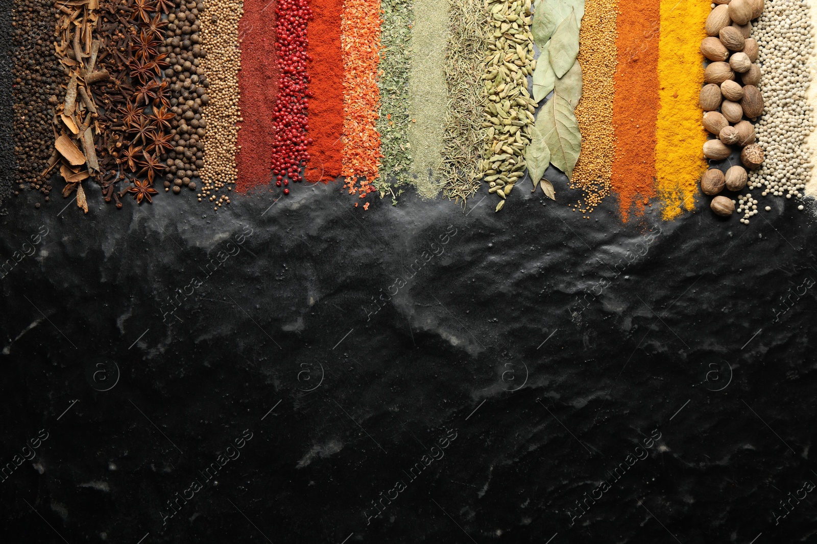 Photo of Many different spices on black table, flat lay. Space for text